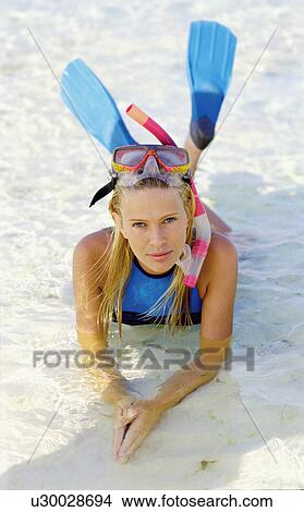 Picture - Portrait of woman snorkeler lying in sea. Fotosearch