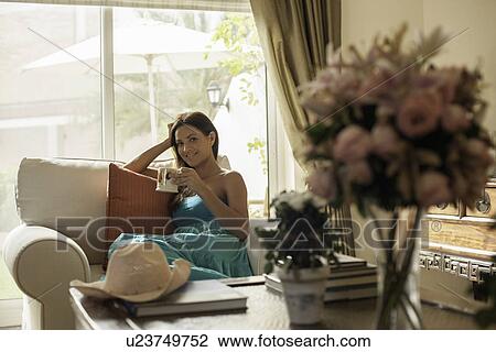 Portrait of young woman on armchair with coffee cup View Large Photo Image Stock Image - Portrait of young woman on armchair with coffee cup. Fotosearch