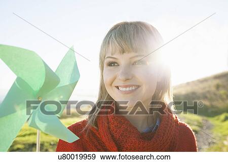 Portrait of young woman with paper windmill View Large Photo Image Stock Photo - Portrait of young woman with paper windmill. Fotosearch