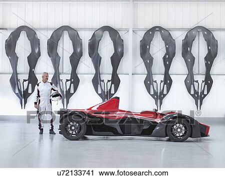 Racing driver with supercar in factory with carbon fibre car body shells hanging on wall View Large Photo Image Stock Image - Racing driver with supercar in factory with carbon fibre car body shells hanging on wall. Fotosearch