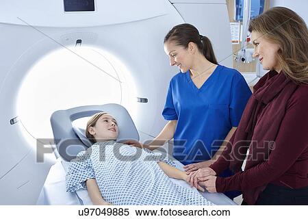 Radiographer and mother reassuring girl going into CT scanner View Large Photo Image Stock Photography - Radiographer and mother reassuring girl going into CT scanner. Fotosearch