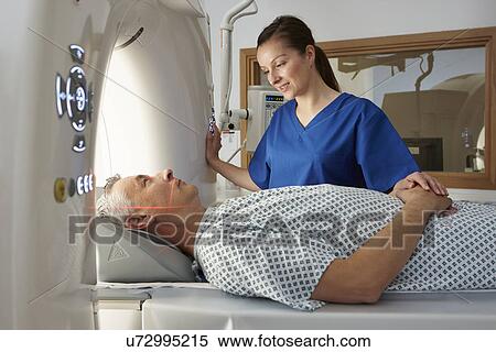 Radiographer reassuring man going into CT scanner View Large Photo Image Stock Photography - Radiographer reassuring man going into CT scanner. Fotosearch