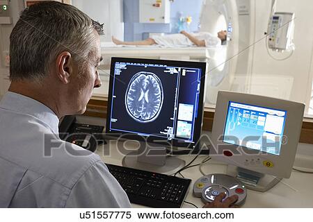 Stock Photography - Radiologist looking at brain scan image on computer screen. Fotosearch