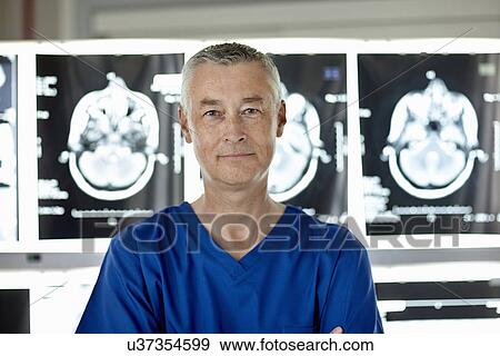 Stock Photo - Radiologist standing in front of brain scans. Fotosearch