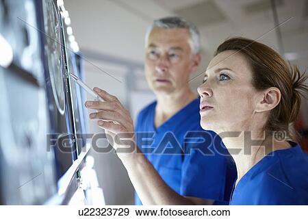 Stock Photo - Radiologists looking at brain scans. Fotosearch