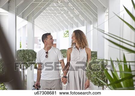 Stock Image - Romantic couple arriving at beach house apartment. Fotosearch
