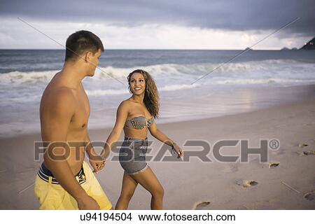Picture - Romantic young couple strolling on Ipanema Beach, Rio de Janeiro, Brazil. Fotosearch