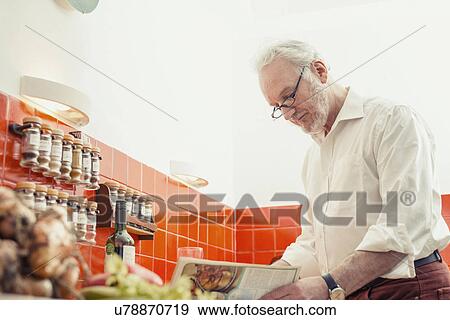 Senior man cooking in kitchen View Large Photo Image Stock Photo - Senior man cooking in kitchen. Fotosearch