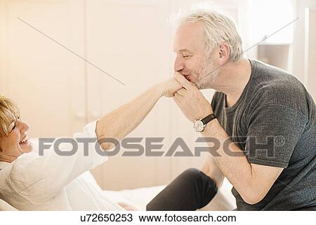Senior man kissing mature woman's hand View Large Photo Image Stock Image - Senior man kissing mature woman's hand. Fotosearch