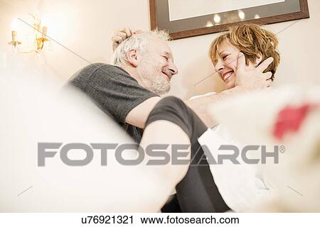 Stock Image - Senior man touching mature woman's face. Fotosearch