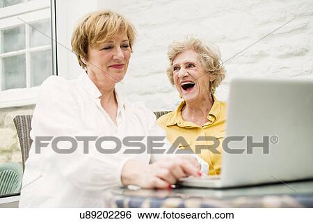 Senior woman and daughter, using laptop View Large Photo Image Stock Photograph - Senior woman and daughter, using laptop. Fotosearch