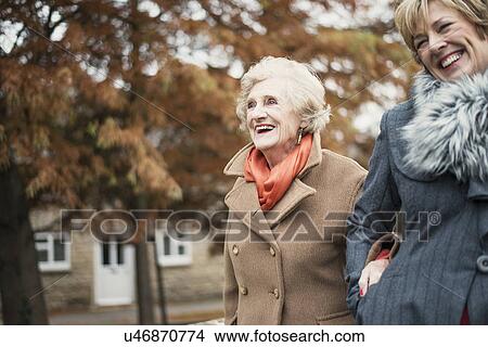 Picture - Senior woman and daughter walking outdoors. Fotosearch