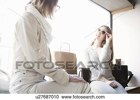 Senior woman and granddaughter trying on sunglasses in shop View Large Photo Image Stock Image - Senior woman and granddaughter trying on sunglasses in shop. Fotosearch