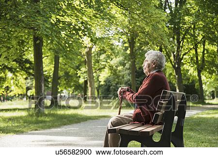 Senior woman sitting on park bench View Large Photo Image Stock Image - Senior woman sitting on park bench. Fotosearch