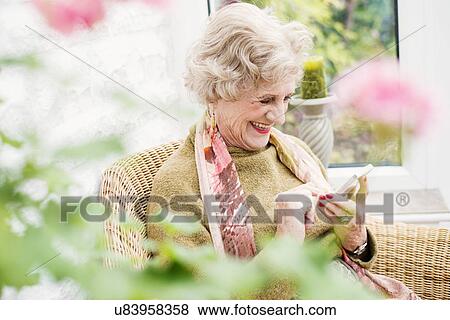 Stock Photo - Senior woman using mobile phone. Fotosearch