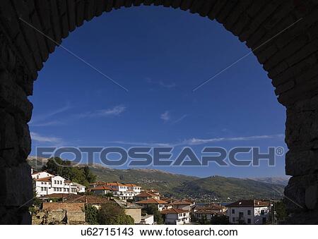 Stock Image -  Silhouetted arch view of Ohrid town and mountains, Macedonia, Eastern Europe. Fotosearch