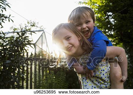 Sister giving brother a piggy back View Large Photo Image Stock Photography - Sister giving brother a piggy back. Fotosearch