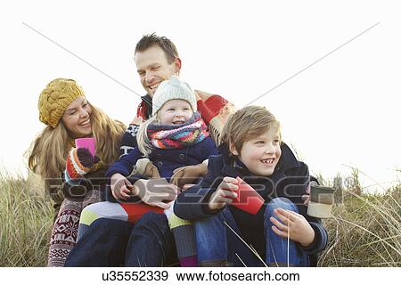 Smiling mid adult couple with two children at coast View Large Photo Image Stock Photo - Smiling mid adult couple with two children at coast. Fotosearch