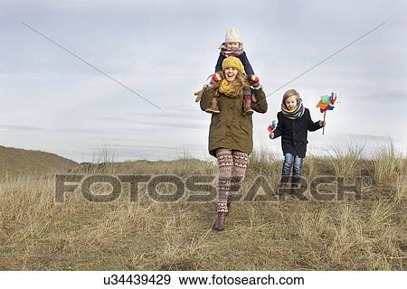 Stock Photo - Smiling mid adult woman with daughter and son at coast. Fotosearch