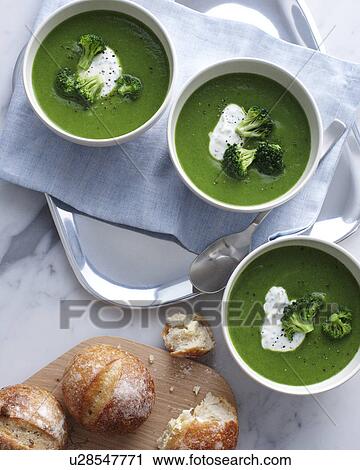 Stock Image - Still life of bowls of broccoli soup with sour cream. Fotosearch