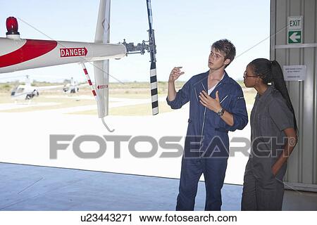 Stock Image - Student pilots sharing helicopter knowledge. Fotosearch