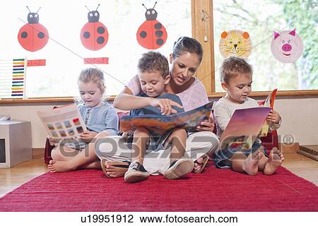 Teacher and pupils reading story books at nursery school View Large Photo Image Stock Image - Teacher and pupils reading story books at nursery school. Fotosearch