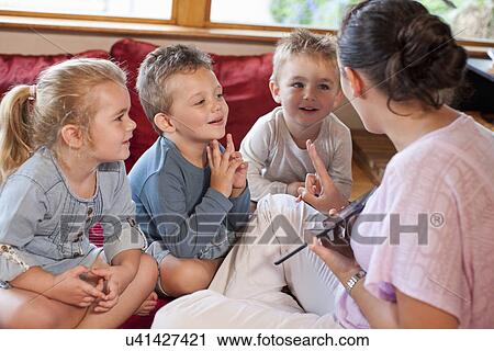 Teacher using digital tablet with pupils at nursery school View Large Photo Image Stock Image - Teacher using digital tablet with pupils at nursery school. Fotosearch