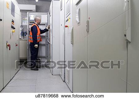 Stock Photo - Technician doing a check in power station control room. Fotosearch