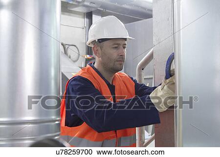 Technician making a check to pipes in power station View Large Photo Image Stock Image - Technician making a check to pipes in power station. Fotosearch