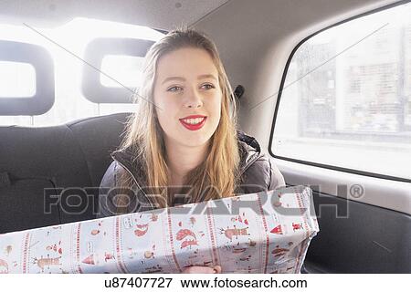 Teenage girl in back seat of cab, holding gift View Large Photo Image Stock Photo - Teenage girl in back seat of cab, holding gift. Fotosearch