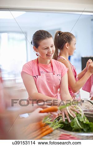 Teenage girls preparing carrots in kitchen View Large Photo Image Picture - Teenage girls preparing carrots in kitchen. Fotosearch
