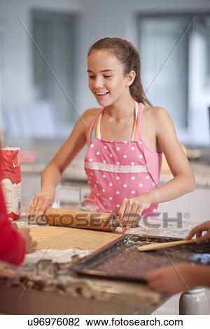 Teenage girls preparing to bake biscuits in kitchen View Large Photo Image Stock Image - Teenage girls preparing to bake biscuits in kitchen. Fotosearch