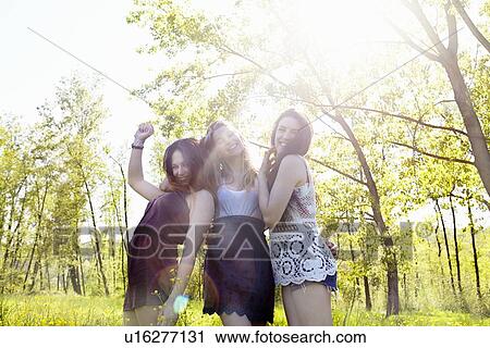 Three female friends in sunlight, portrait View Large Photo Image Stock Image - Three female friends in sunlight, portrait. Fotosearch