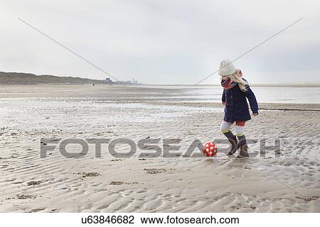 Three year old girl playing football on beach, Bloemendaal aan Zee, Netherlands View Large Photo Image Stock Image - Three year old girl playing football on beach, Bloemendaal aan Zee, Netherlands. Fotosearch