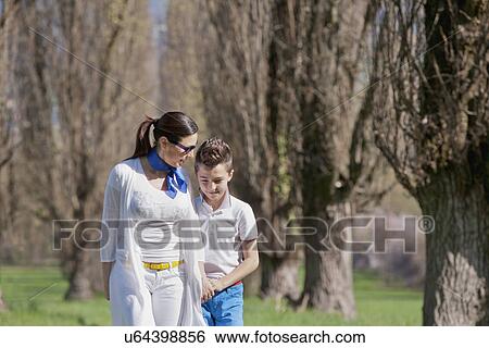 Twelve year old boy and mature mother strolling and chatting View Large Photo Image Stock Photograph - Twelve year old boy and mature mother strolling and chatting. Fotosearch