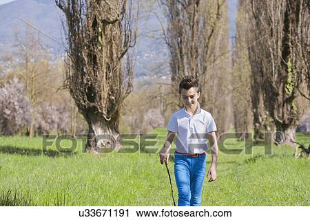 Twelve year old boy strolling with walking stick View Large Photo Image Stock Image - Twelve year old boy strolling with walking stick. Fotosearch