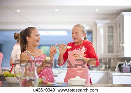 Two teenage girls tasting sour lemons in kitchen View Large Photo Image Stock Photo - Two teenage girls tasting sour lemons in kitchen. Fotosearch