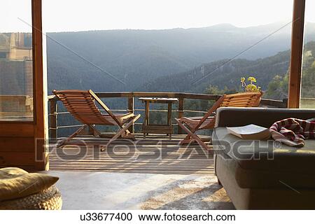 Stock Image - View from sitting room onto sunlit rural balcony. Fotosearch