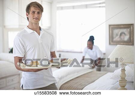 Stock Photo - Waiter and chambermaid in holiday apartment bedroom. Fotosearch