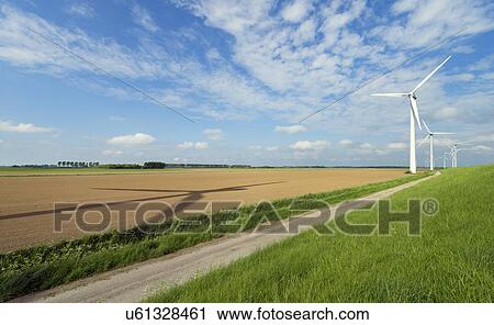 Stock Image - Wind turbines on the dyke, Netherlands. Fotosearch