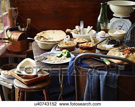 Stock Image - Winter pie selection among kitchen scales and utensils. Fotosearch