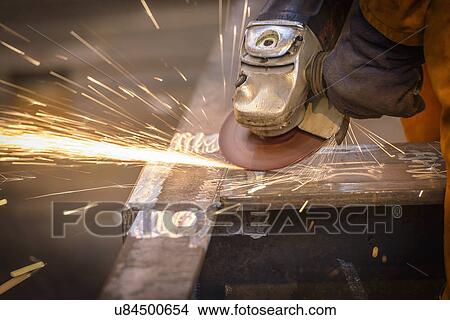 Worker grinding metal construction in marine fabrication factory View Large Photo Image Picture - Worker grinding metal construction in marine fabrication factory. Fotosearch