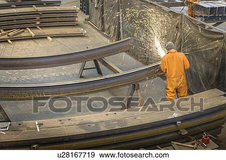 Worker grinding metal construction in marine fabrication factory, high angle view View Large Photo Image Stock Photo - Worker grinding metal construction in marine fabrication factory, high angle view. Fotosearch