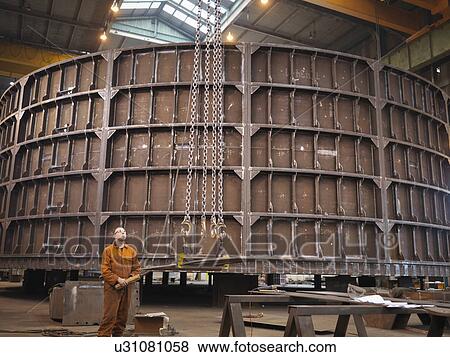 Worker operating crane in marine fabrication factory View Large Photo Image Stock Photo - Worker operating crane in marine fabrication factory. Fotosearch