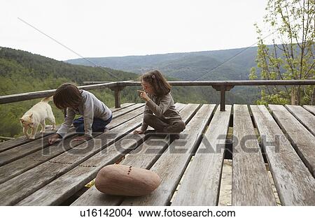Picture - Young brother and sister playing on rural balcony. Fotosearch