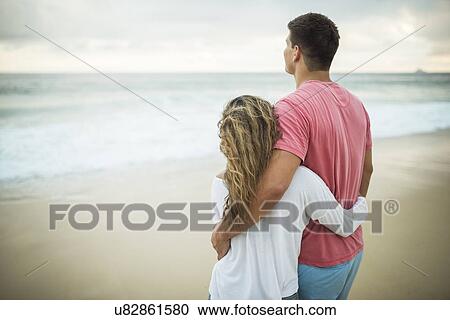 Stock Image - Young couple gazing at ocean, Ipanema Beach, Rio de Janeiro, Brazil. Fotosearch