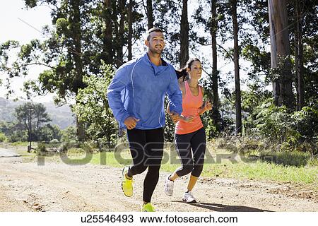 Young couple jogging in forest View Large Photo Image Stock Image - Young couple jogging in forest. Fotosearch