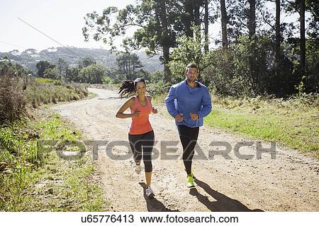 Young couple jogging in forest View Large Photo Image Stock Image - Young couple jogging in forest. Fotosearch