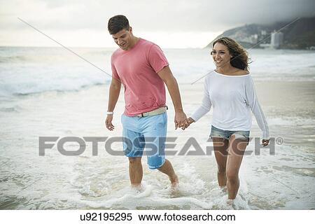 Stock Photography - Young couple paddling in ocean, Ipanema Beach, Rio de Janeiro, Brazil. Fotosearch