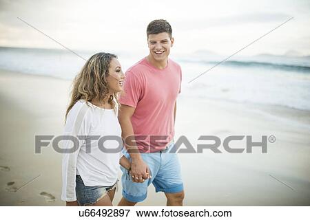 Young couple strolling hand in hand on Ipanema Beach, Rio de Janeiro, Brazil View Large Photo Image Stock Photo - Young couple strolling hand in hand on Ipanema Beach, Rio de Janeiro, Brazil. Fotosearch